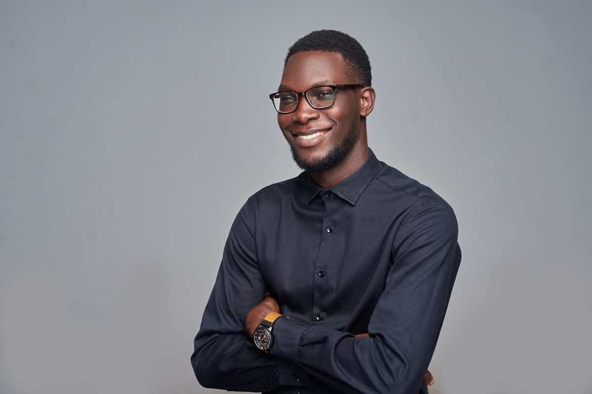 Portrait of an engineer in a dark shirt and glasses, arms folded