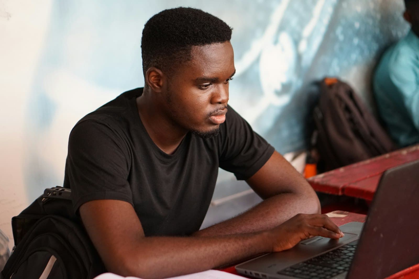 Engineer concentrating on a laptop screen while working through a problem